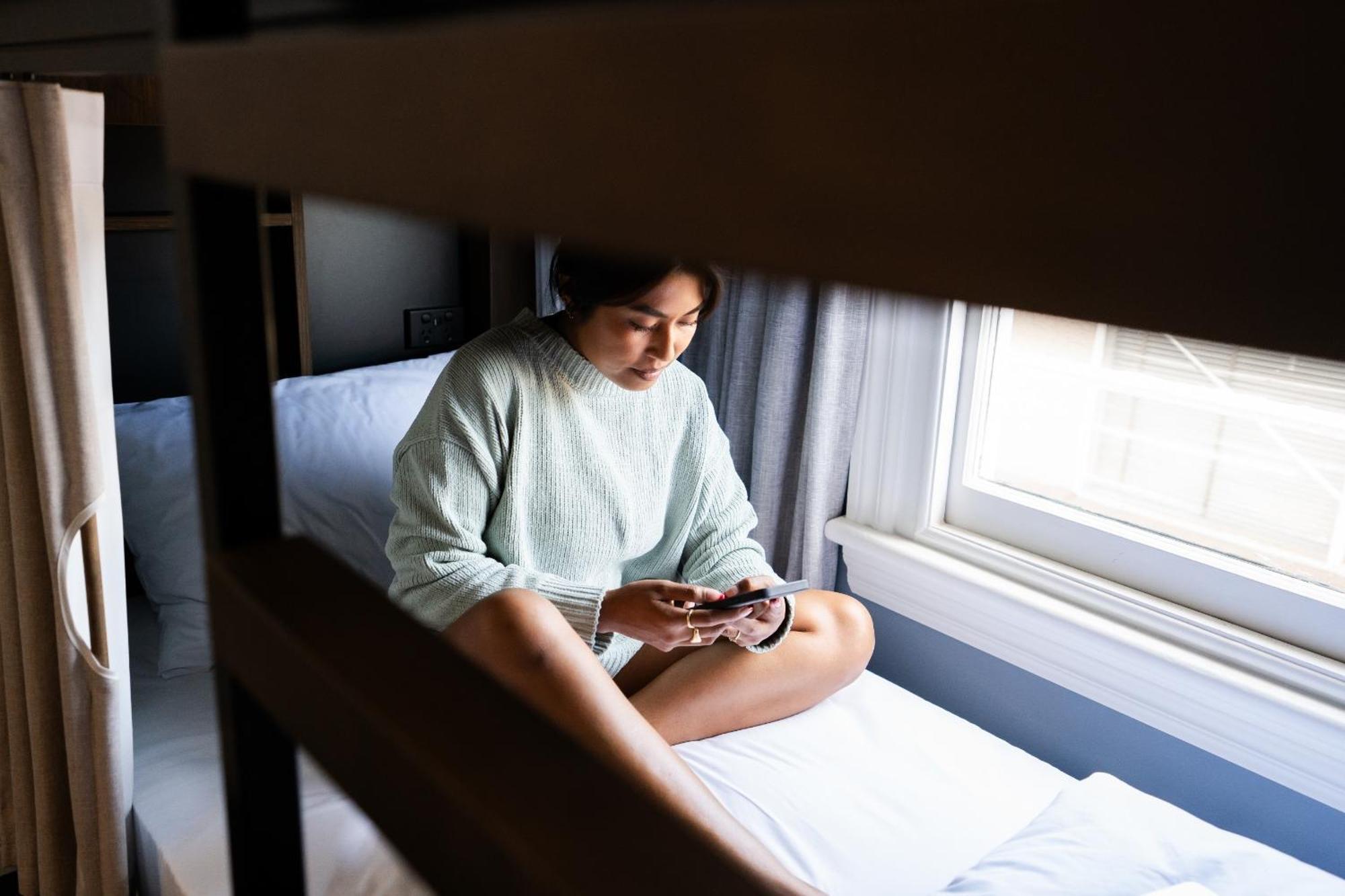 Haka House Christchurch Cameră foto A woman sitting on a bunk bed